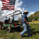 A man walks beneath an American flag at the Owsley County Saddle Club trail ride on April 20, 2012, in Booneville, Ky. The trail ride attracts riders from outside the county who contribute much-needed revenue. The 2010 U.S. census listed Owsley County as having the lowest median household income in the country outside of Puerto Rico, with 41.5 percent of residents living below the poverty line.